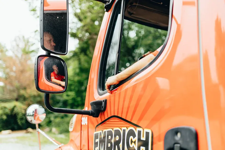 Close-up of Embrich Plumbing, Heating & Air Conditioning branded orange service truck door in Collinsville