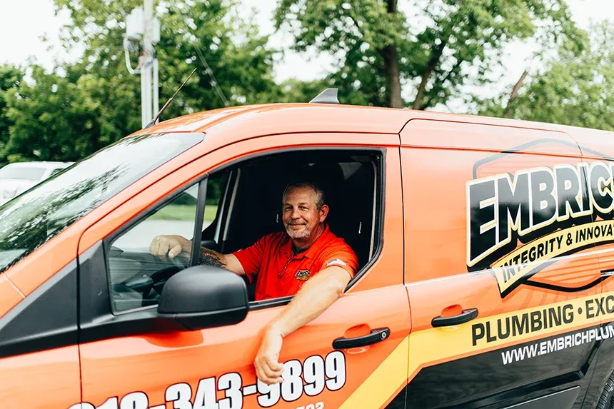 Embrich Plumbing, Heating & Air Conditioning service expert driving company plumbing service truck in Collinsville