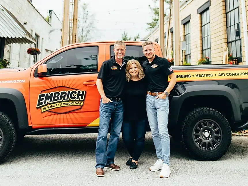 Embrich Plumbing, Heating & Air Conditioning team members beside branded plumbing service truck in Collinsville
