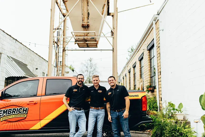 Embrich Plumbing, Heating & Air Conditioning team standing beside service truck at plumbing job site in Collinsville