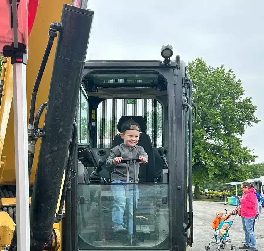 Embrich Plumbing, Heating & Air Conditioning Touch-A-Truck event with child sitting inside excavator cab