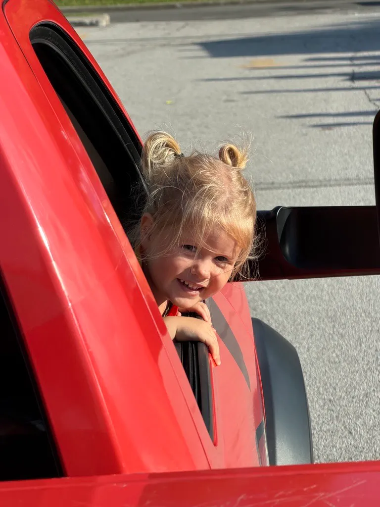 Smiling child riding in an Embrich truck at the Maryville Fireman’s Picnic Parade