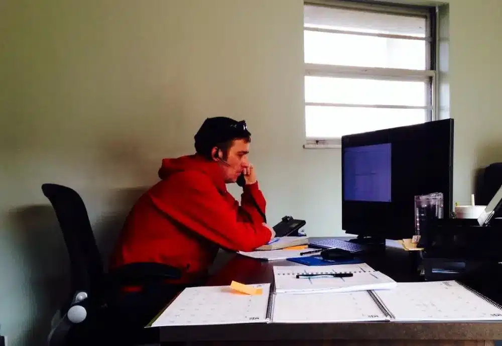 Embrich Plumbing, Heating & Air Conditioning team member working at desk handling scheduling and customer service