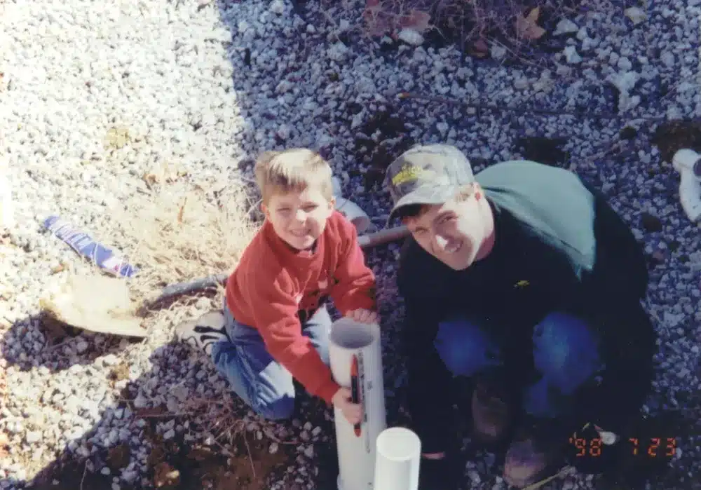 Embrich Plumbing, Heating & Air Conditioning technician assisting customer with outdoor plumbing repair