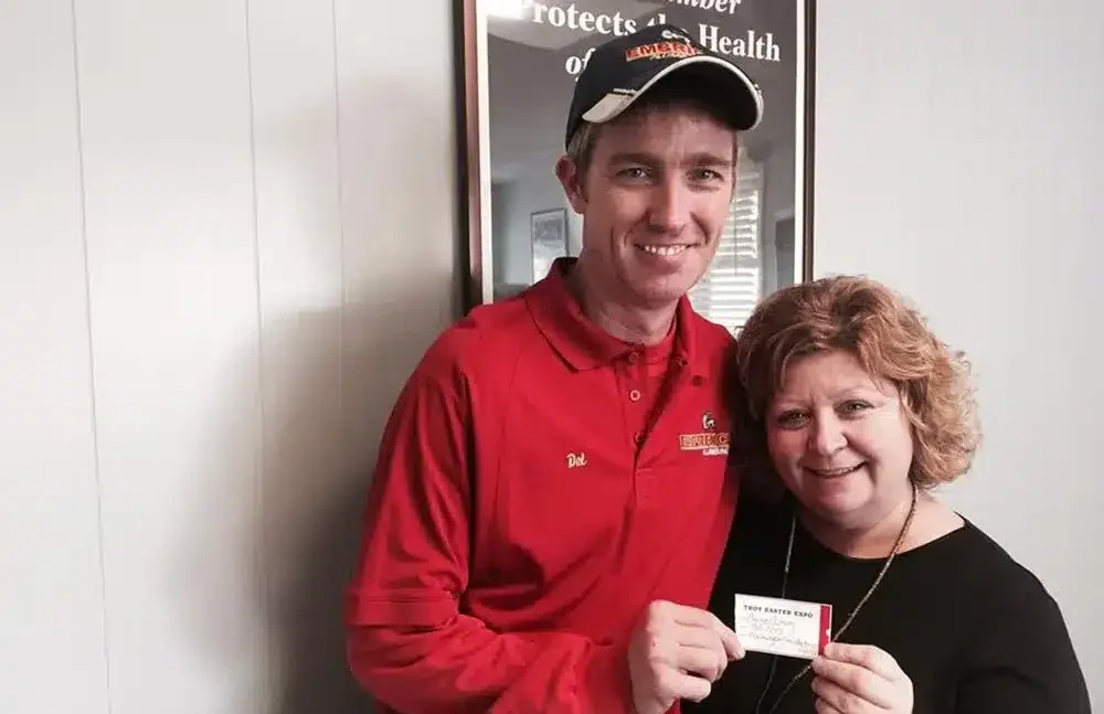 Embrich Plumbing, Heating & Air Conditioning technician presenting card of Easter Expo