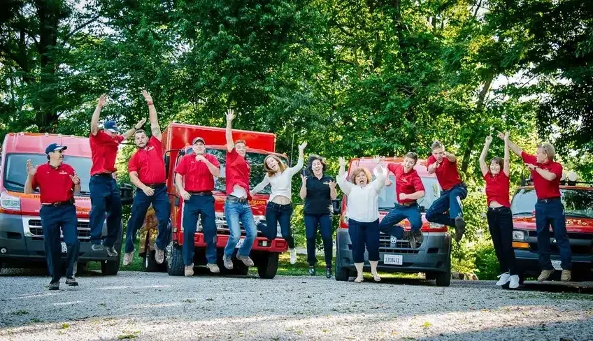 Embrich Plumbing, Heating & Air Conditioning team gathered outdoors in uniform for company group photo