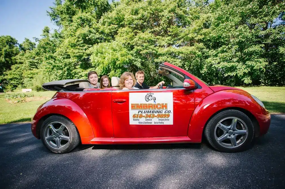 Embrich Plumbing, Heating & Air Conditioning branded service vehicle driving through residential neighborhood