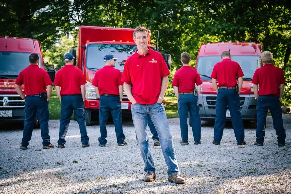 Embrich Plumbing, Heating & Air Conditioning team lined up in uniform in front of service trucks