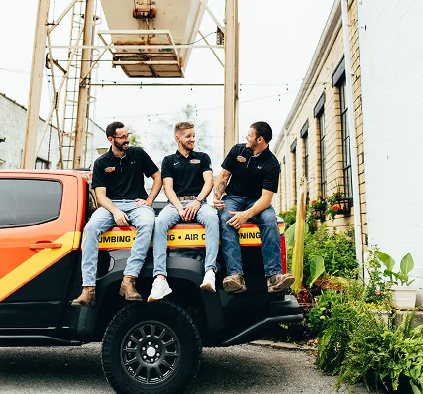 Embrich Plumbing, Heating & Air Conditioning service experts sitting on service truck at commercial plumbing job location in Collinsville