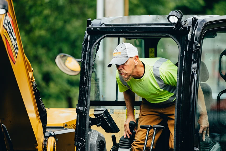 Embrich Plumbing, Heating & Air Conditioning service expert operating compact excavator for plumbing excavation work in Collinsville