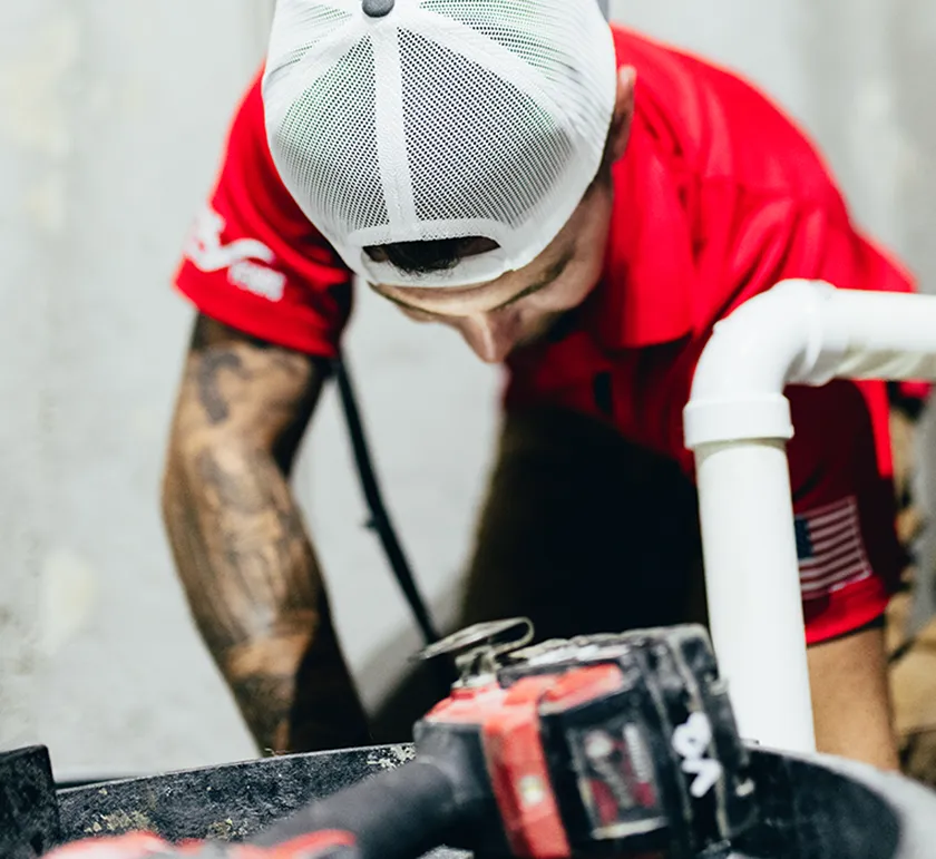 Embrich Plumbing, Heating & Air Conditioning service expert using power tools during residential plumbing repair in Collinsville