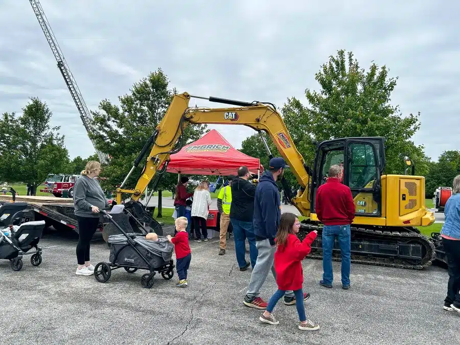 Families visiting heavy equipment display at Embrich Plumbing Touch-A-Truck community event