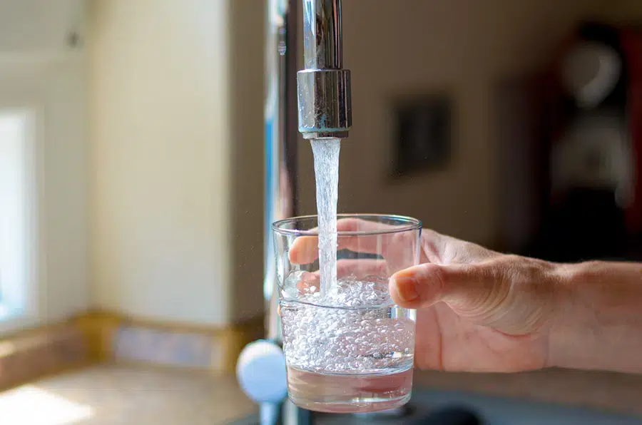 Clean water flowing from faucet into glass.